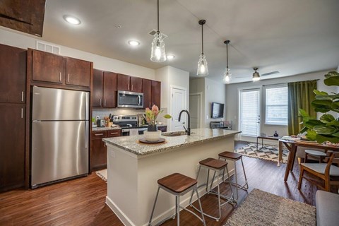 a kitchen with a bar and a stainless steel refrigerator